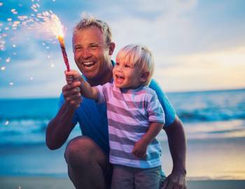 family on the beach with fireworks