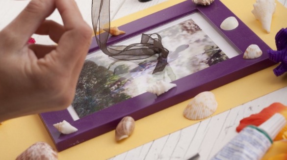 woman using seashells in scrapbook | Better Beach Rentals